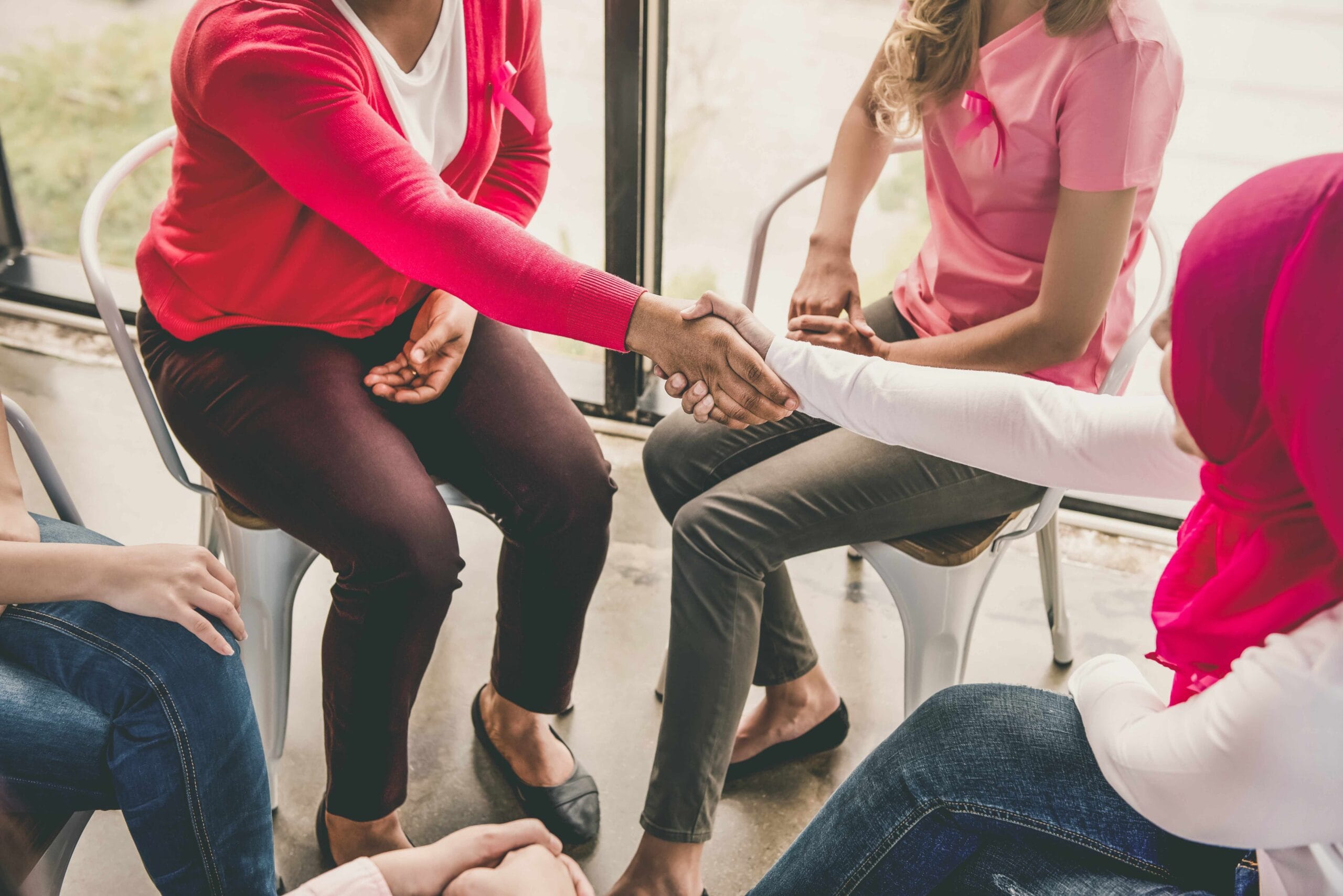 Two women making handshake greeting each other in group meeting